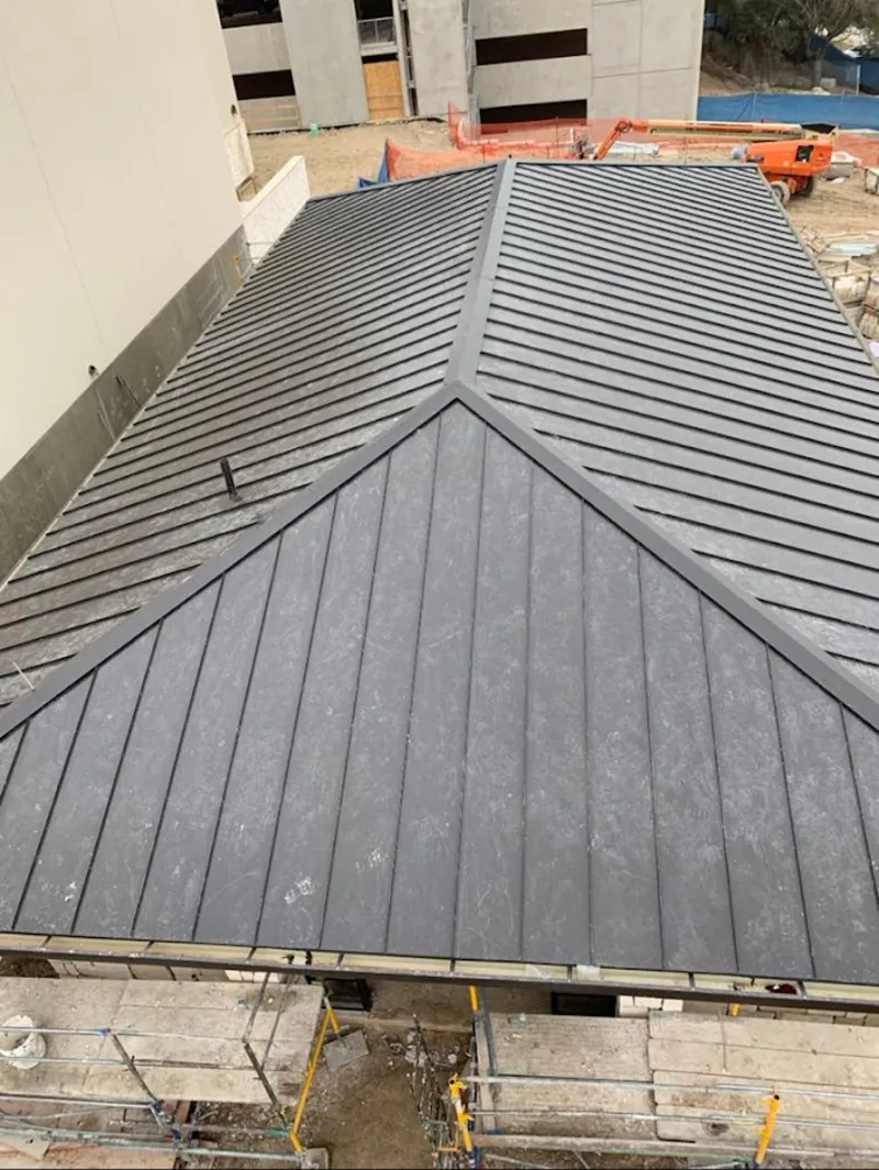 Commercial metal roof construction with crane equipment in Hunters Creek