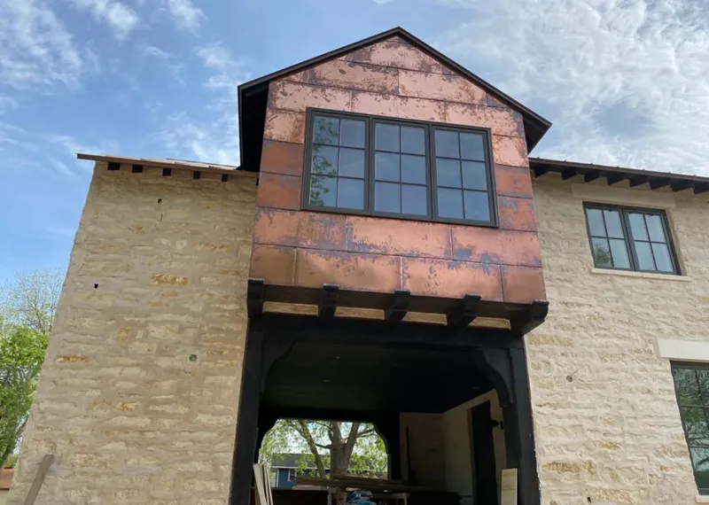 Copper metal panel facade on a stone building for Roof Repair in Hunters Creek